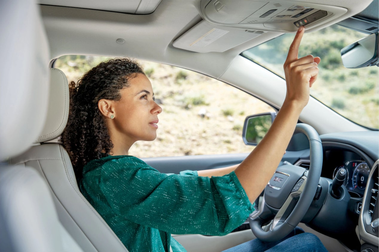 Woman Driver in Green Blouse Pressing OnStar Button