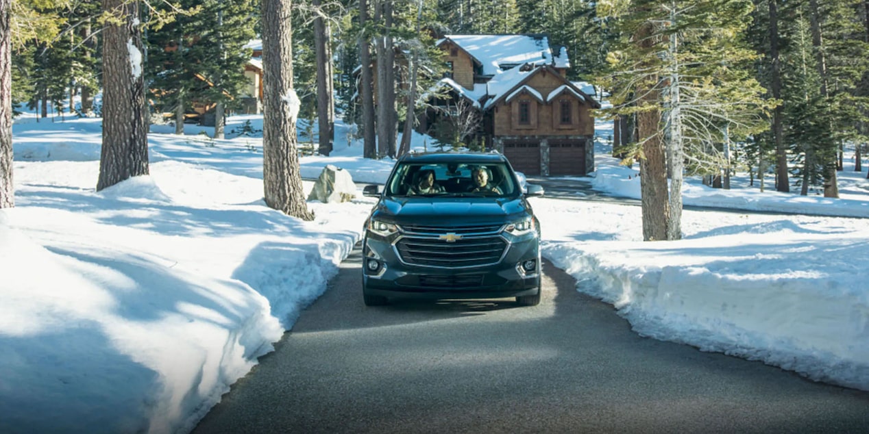 Chevy Vehicle Drives Down a Narrow Road in Winter