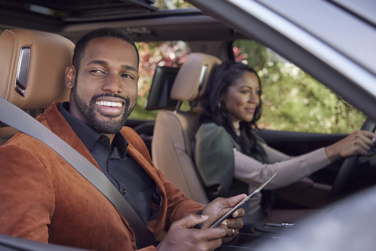 Couple Smiling in Their GM Vehicle With Woman Driving