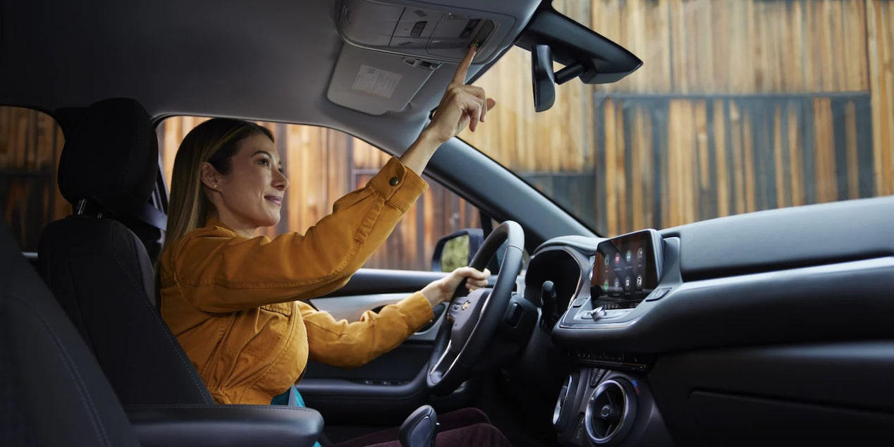 Woman Driver in Yellow Blouse Pressing OnStar Button