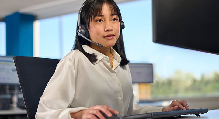 A female OnStar advisor wearing a headset and looking at her computer